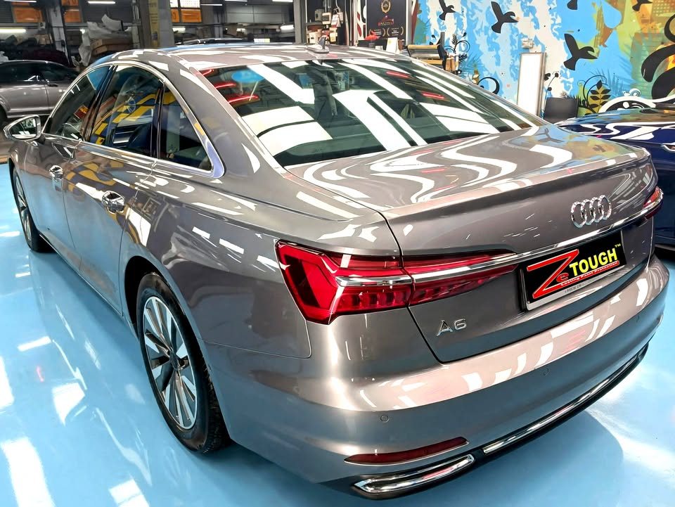 Rear three-quarter view of the grey Audi A6 showing the boot lid and tail lights.