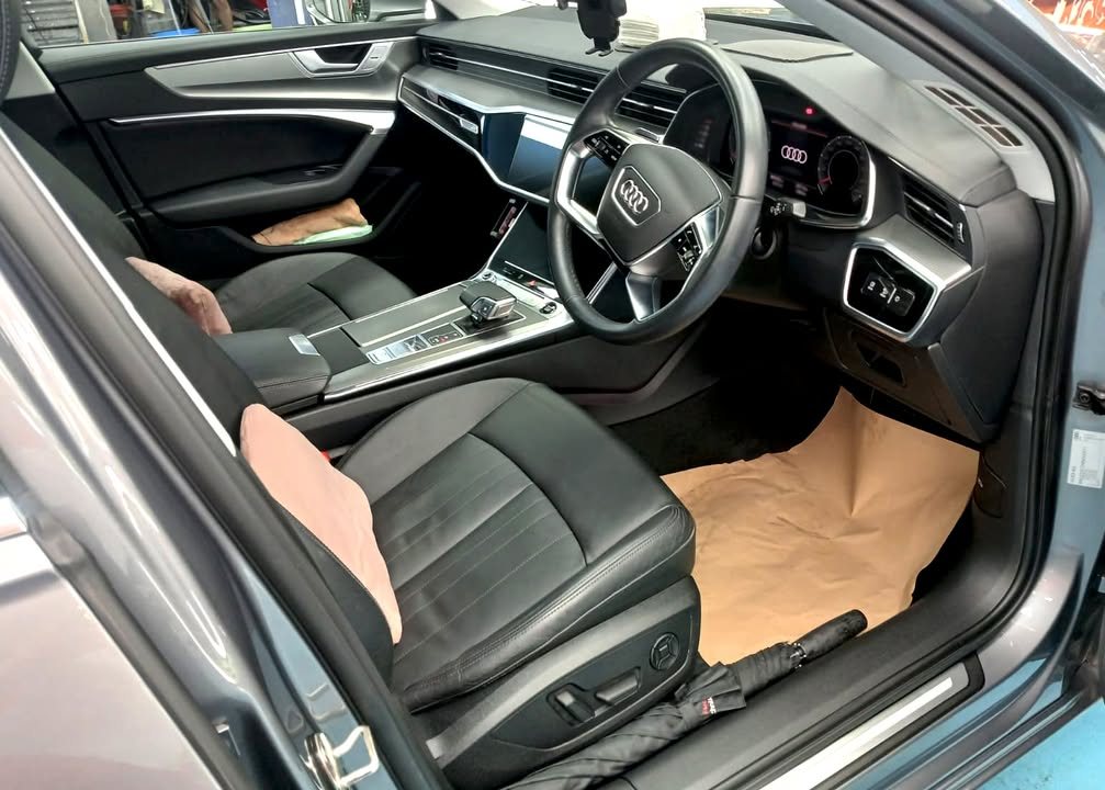 Audi A6 interior with black leather seats and steering wheel.