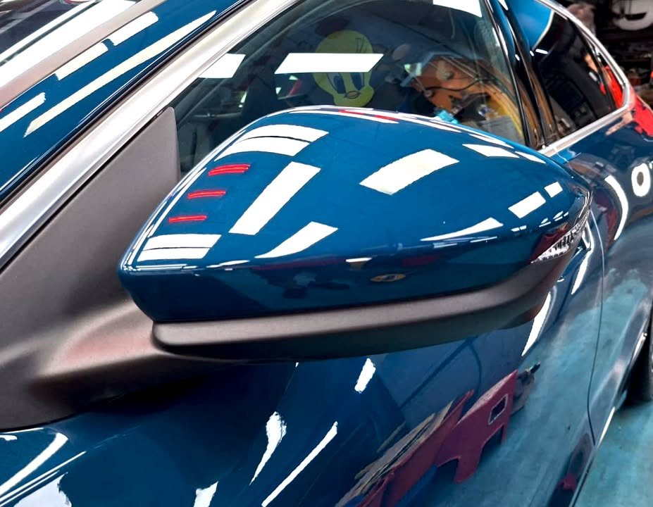 Blue wing mirror on the A6 with a gloss reflection.