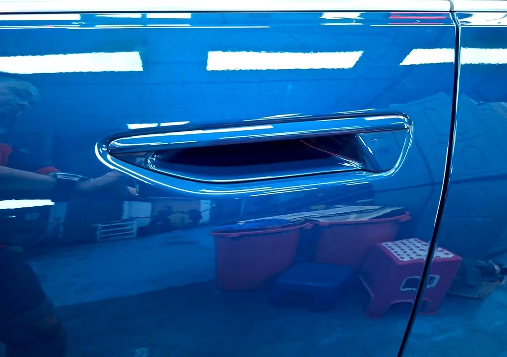 Door handle on the blue A6 door panel.