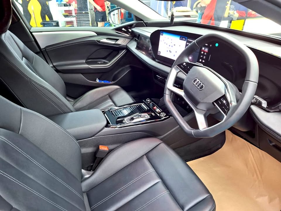 Front cabin of the A6 with dark seats and a wide dashboard display.