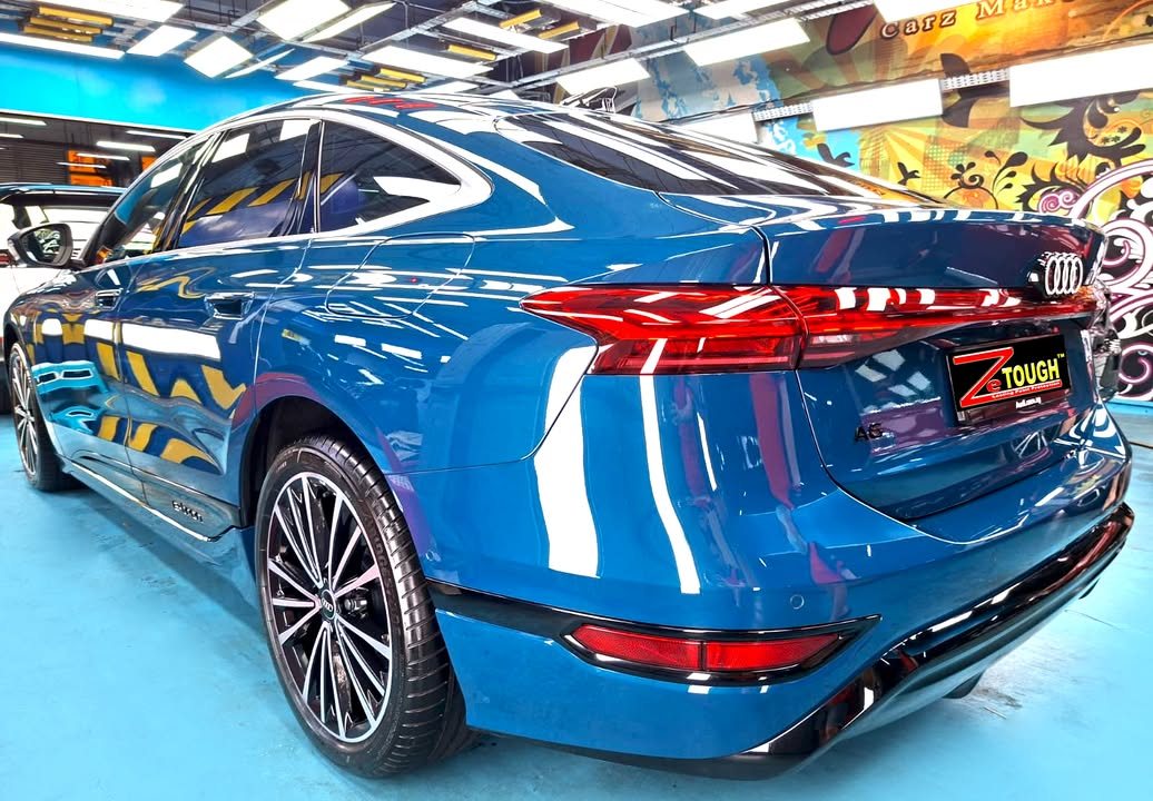 Rear three-quarter view of the blue Audi A6.