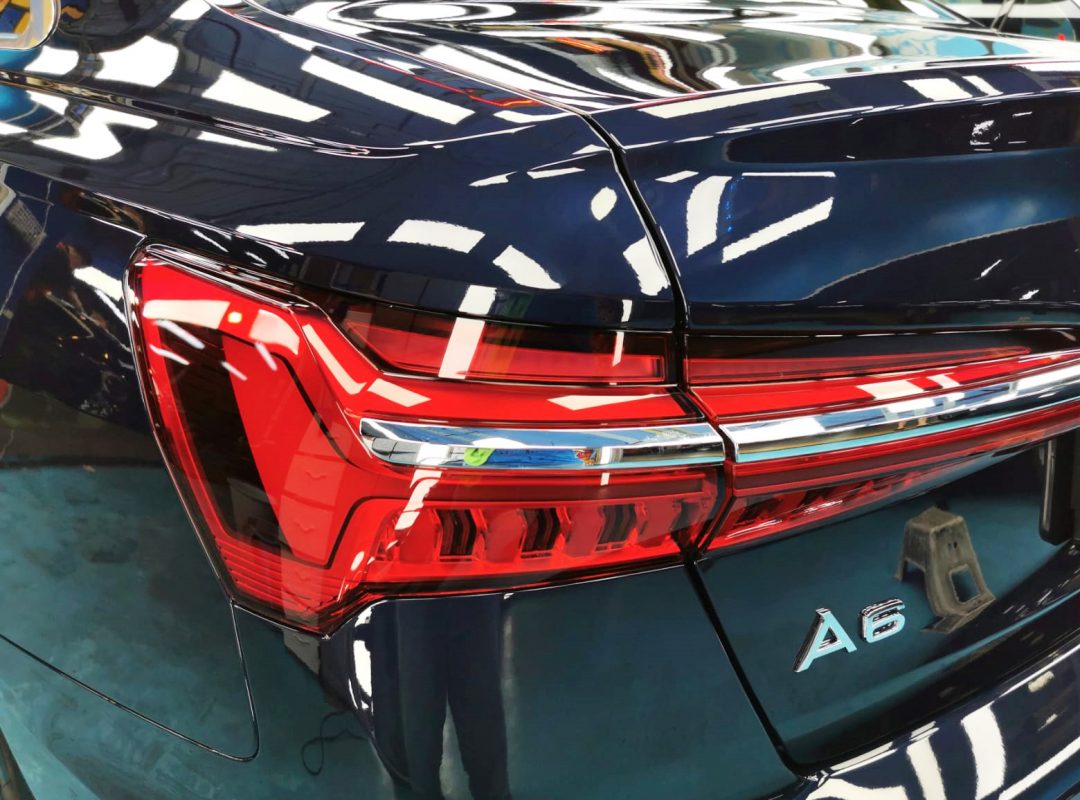 The coated bonnet of the Audi A6 under workshop lighting.