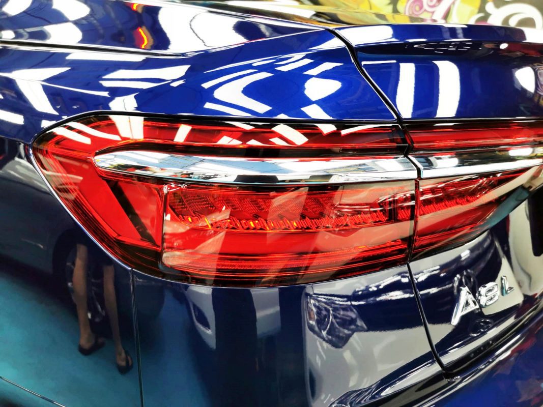The coated bonnet of the Audi A8L under workshop lighting.