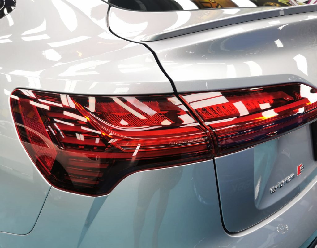 The coated bonnet of the Audi e-tron under workshop lighting.