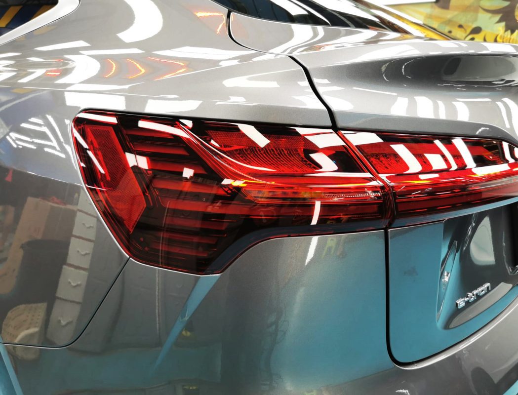 The coated bonnet of the Audi e-tron under workshop lighting.