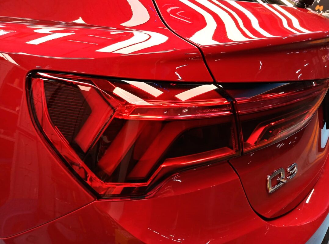 The coated bonnet of the Audi Q3 under workshop lighting.
