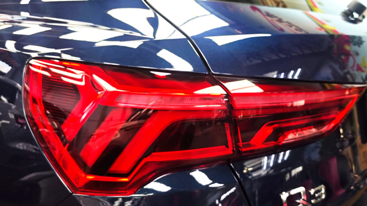 The coated bonnet of the Audi Q3 under workshop lighting.