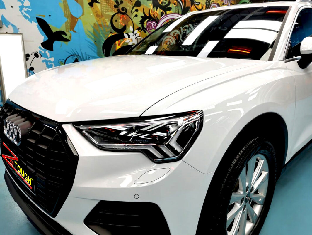 The Audi Q3's coated paintwork under workshop lighting.