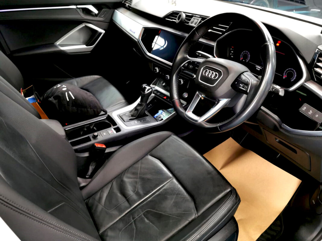 Reflections across the coated panels of the Audi Q3.