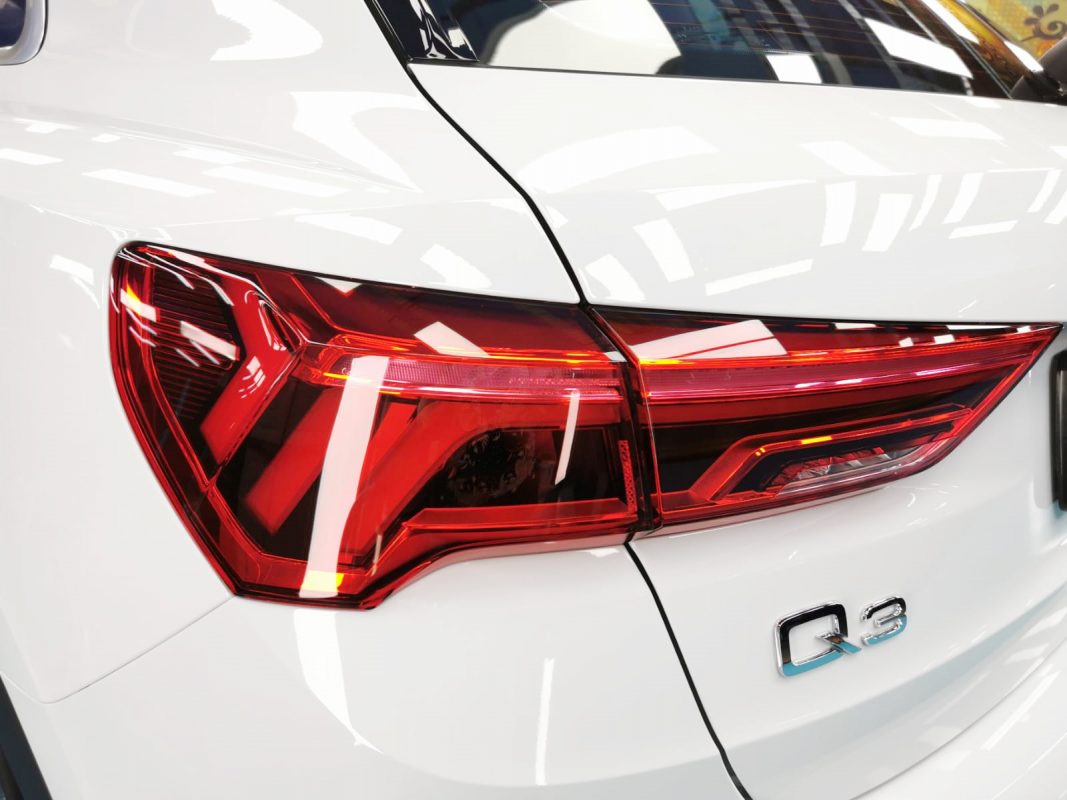 The coated bonnet of the Audi Q3 under workshop lighting.
