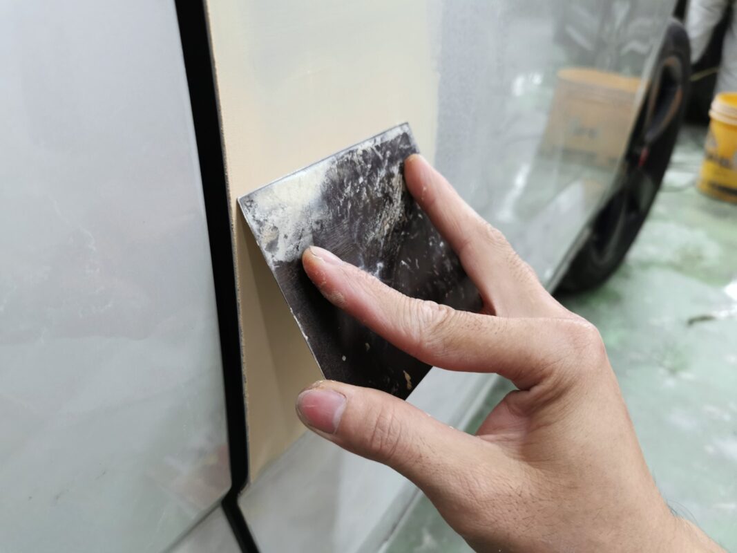 Patching imperfections on the Audi Q3 bodywork ahead of sanding.