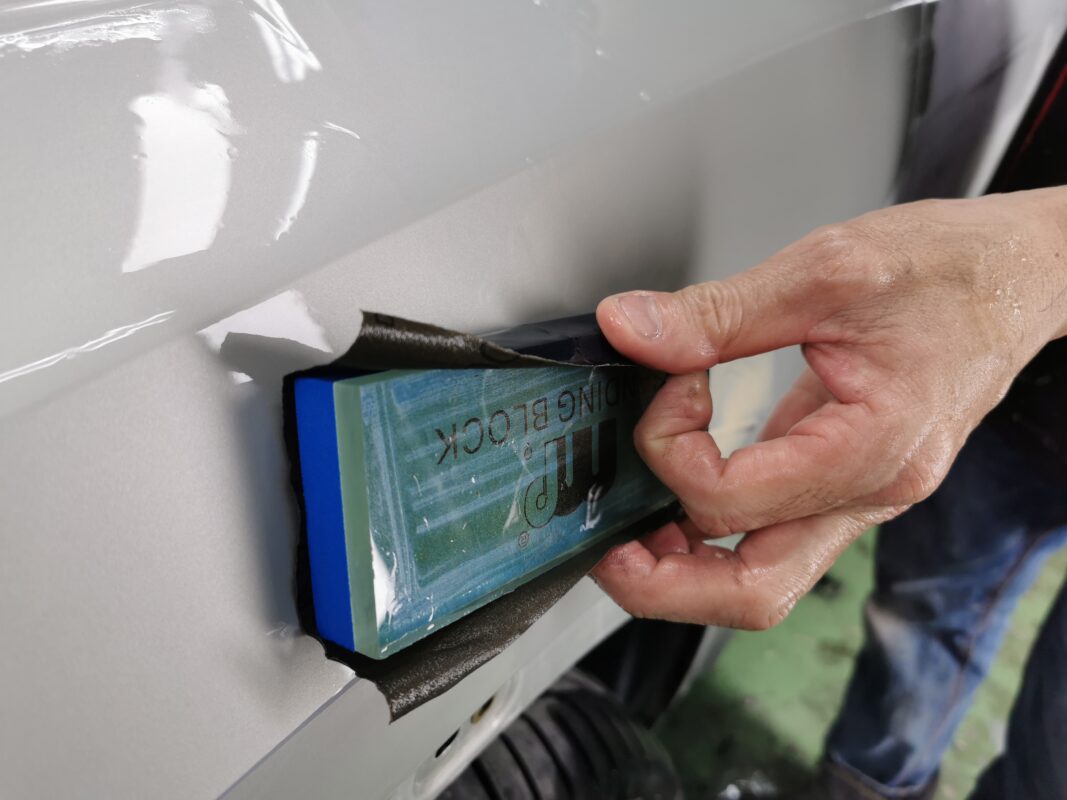 Wet-sanding the Audi Q3 surface to bring it smooth and level.