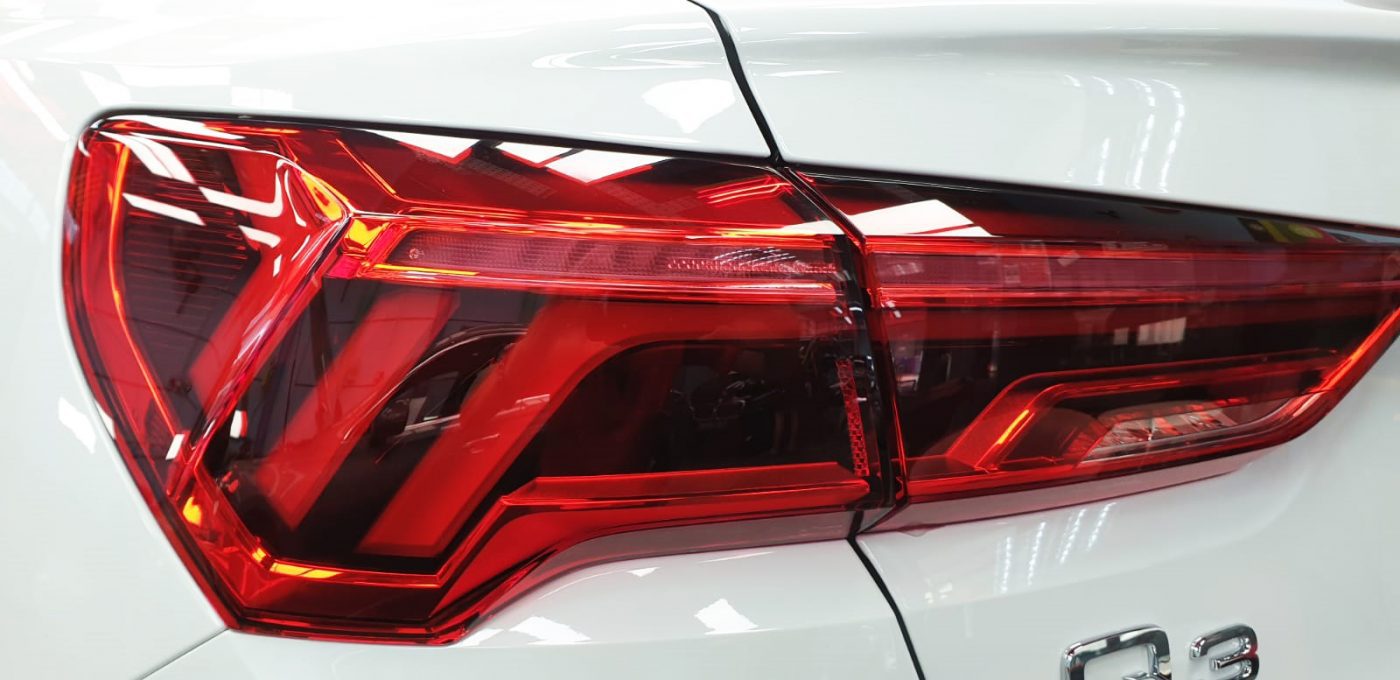 The coated bonnet of the Audi Q3 under workshop lighting.
