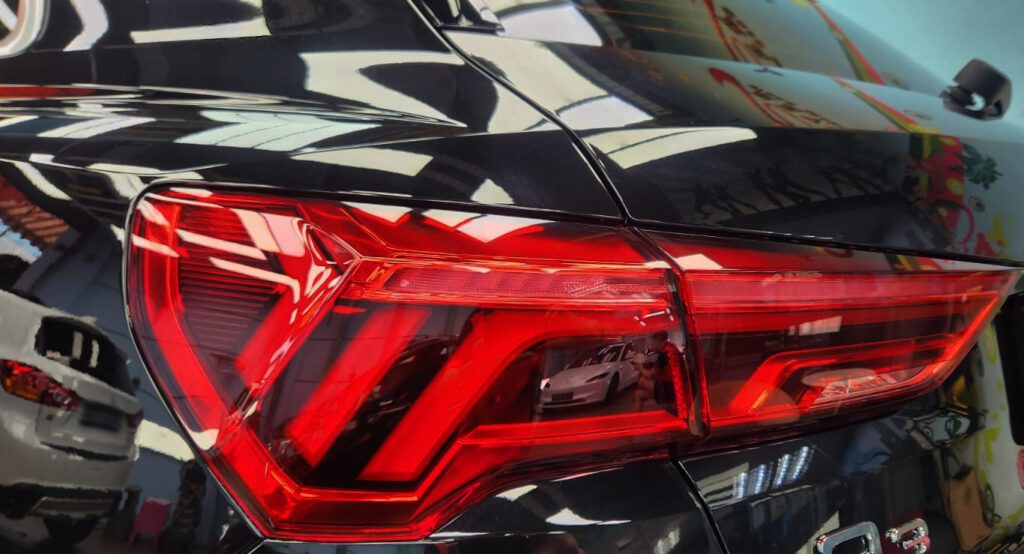 The coated bonnet of the Audi Q3 under workshop lighting.
