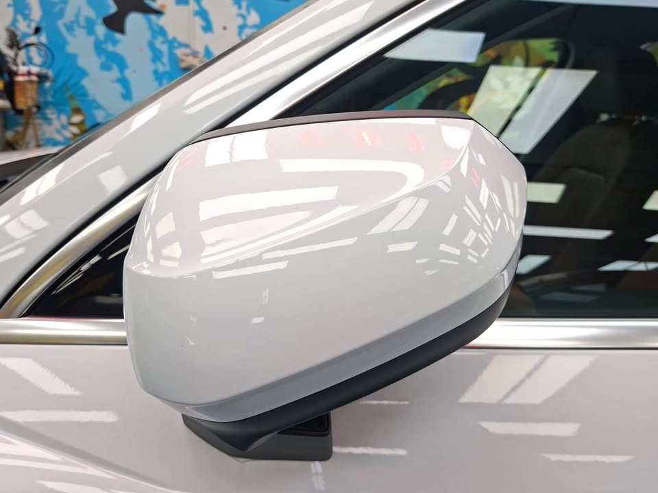 White wing mirror on the Audi Q3 reflecting the workshop lights.
