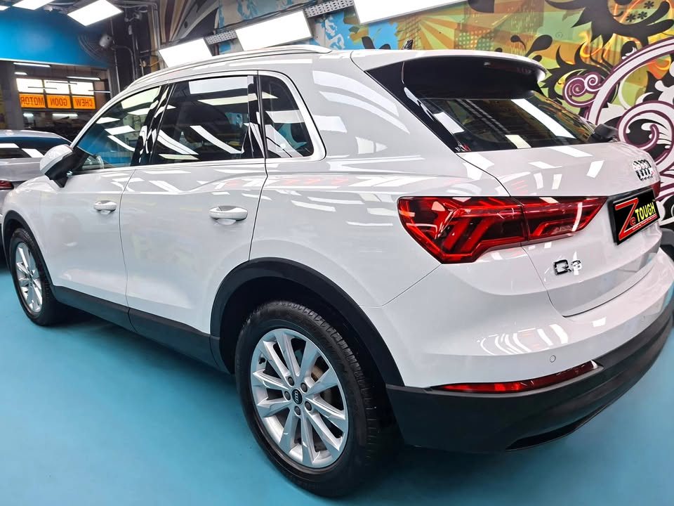 White Audi Q3, rear three-quarter view, in the workshop.