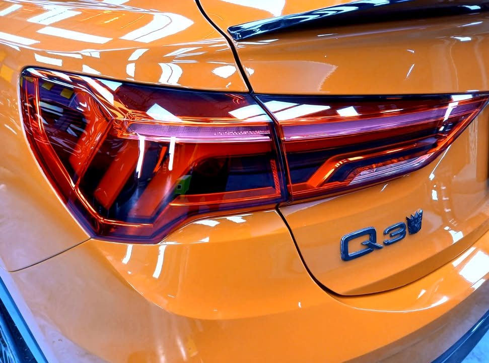 Close-up of the red tail light and Q3 badge on the orange tailgate.