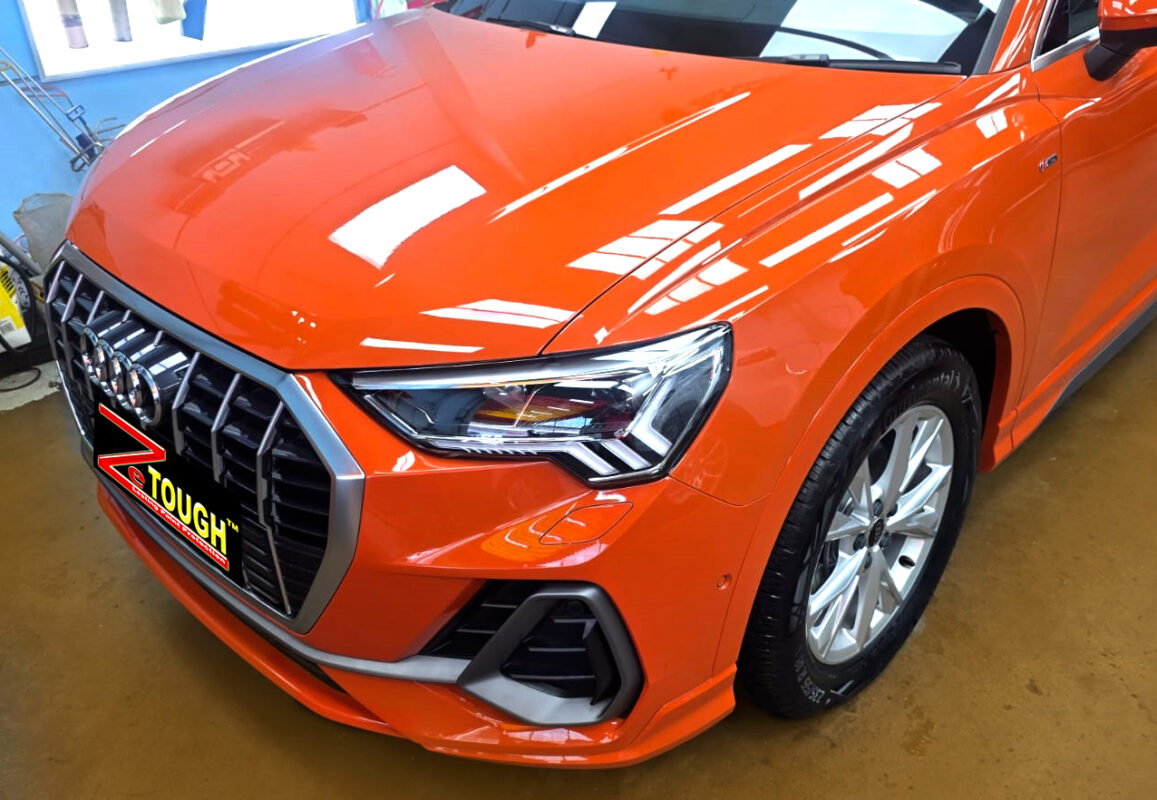 The Audi Q3's coated paintwork under workshop lighting.