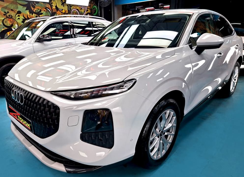 White Audi Q3, front three-quarter view, in the Revol Carz workshop after coating.
