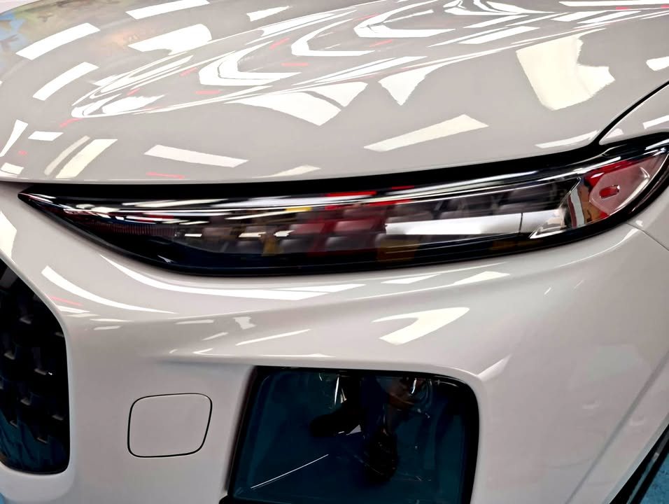 Close-up of the Audi Q3 headlight strip and white front bumper.