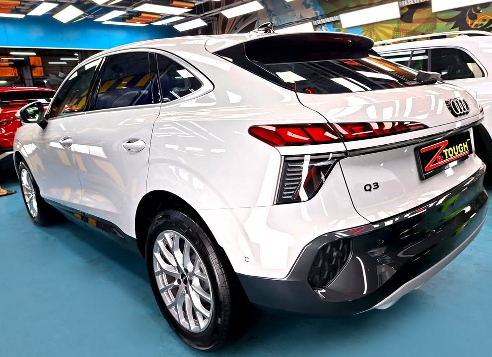 White Audi Q3, rear three-quarter view, in the workshop.