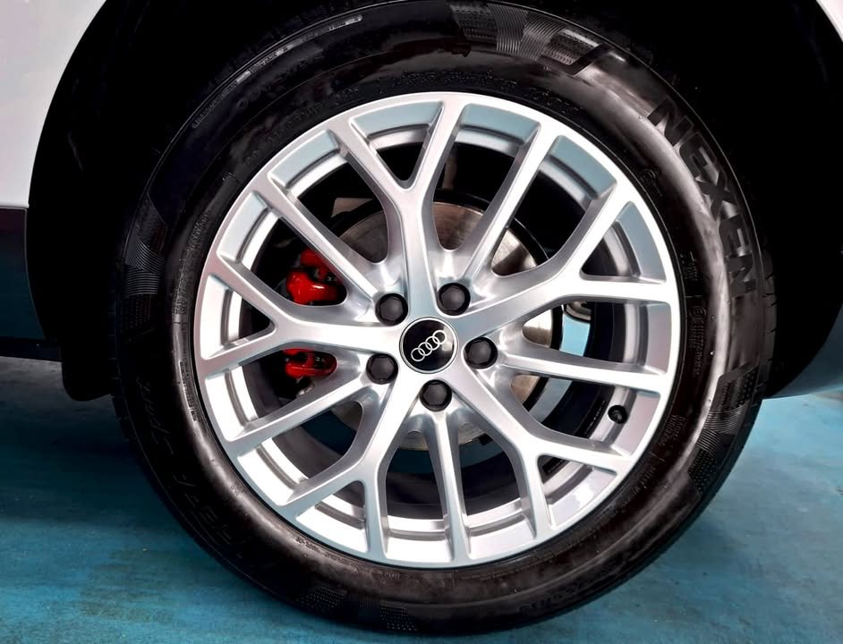 Silver multi-spoke alloy wheel with red brake caliper on the Audi Q3.