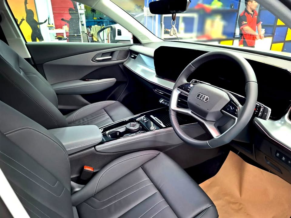 Audi Q3 cabin with grey seats, steering wheel and curved display after detailing.