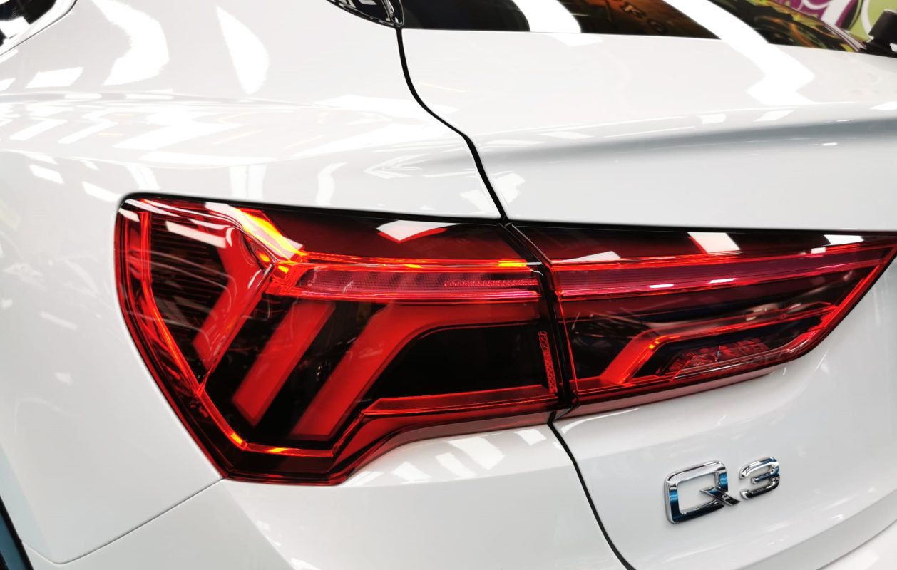 The coated bonnet of the Audi Q3 under workshop lighting.