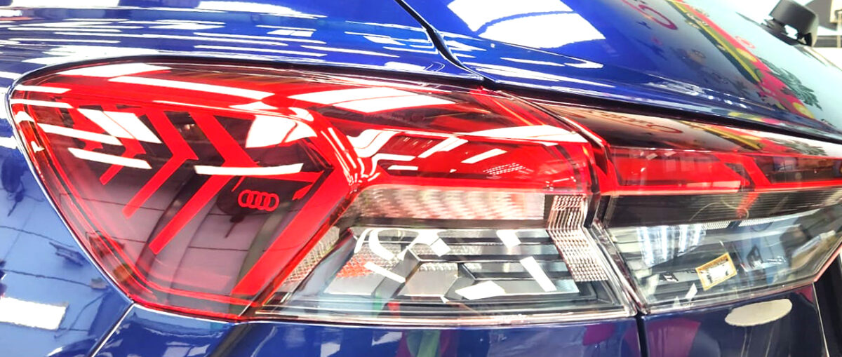 The coated bonnet of the Audi Q4 under workshop lighting.