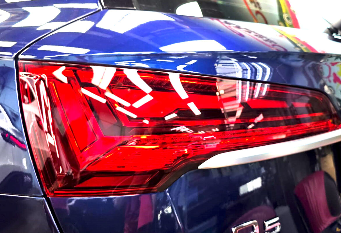 The coated bonnet of the Audi Q5 under workshop lighting.