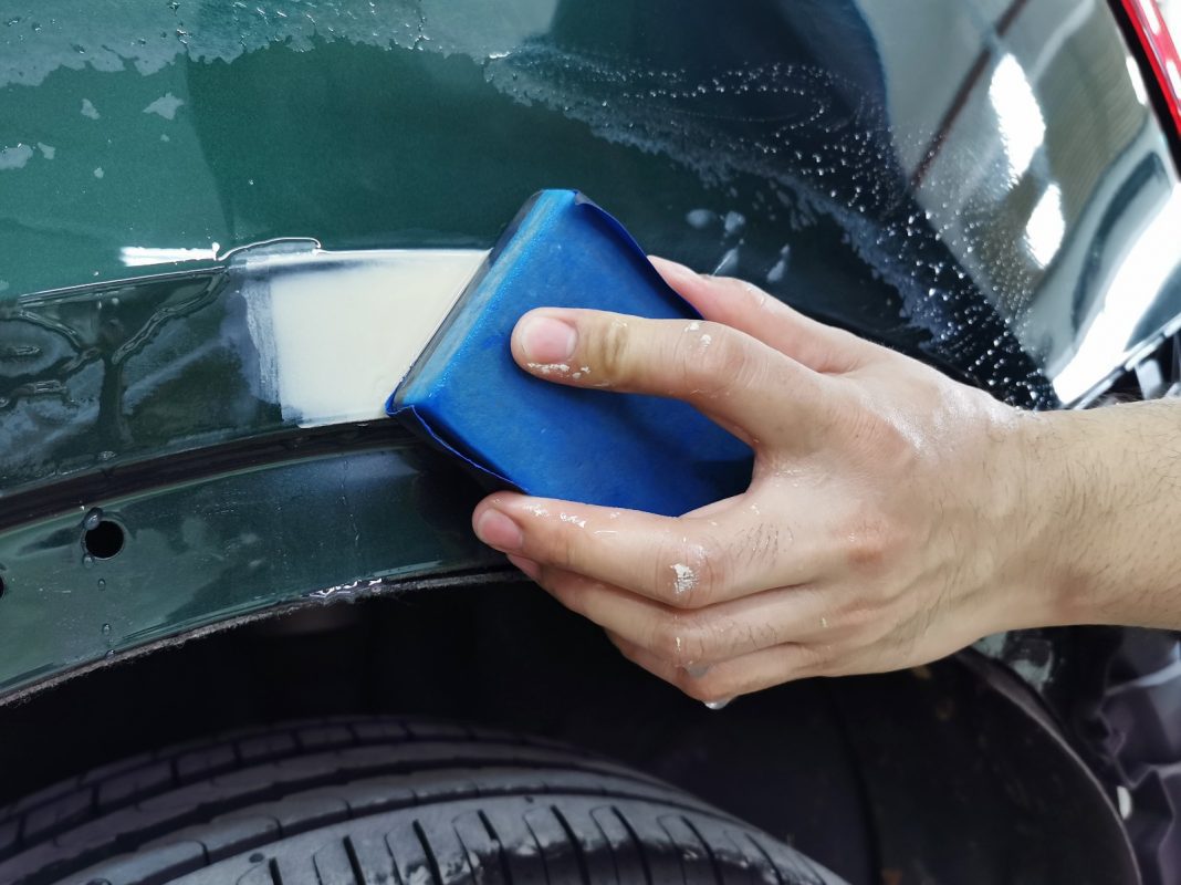 Wet-sanding the Q5's panels to smooth the existing paintwork.