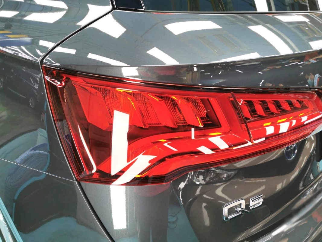 The coated bonnet of the Audi Q5 under workshop lighting.