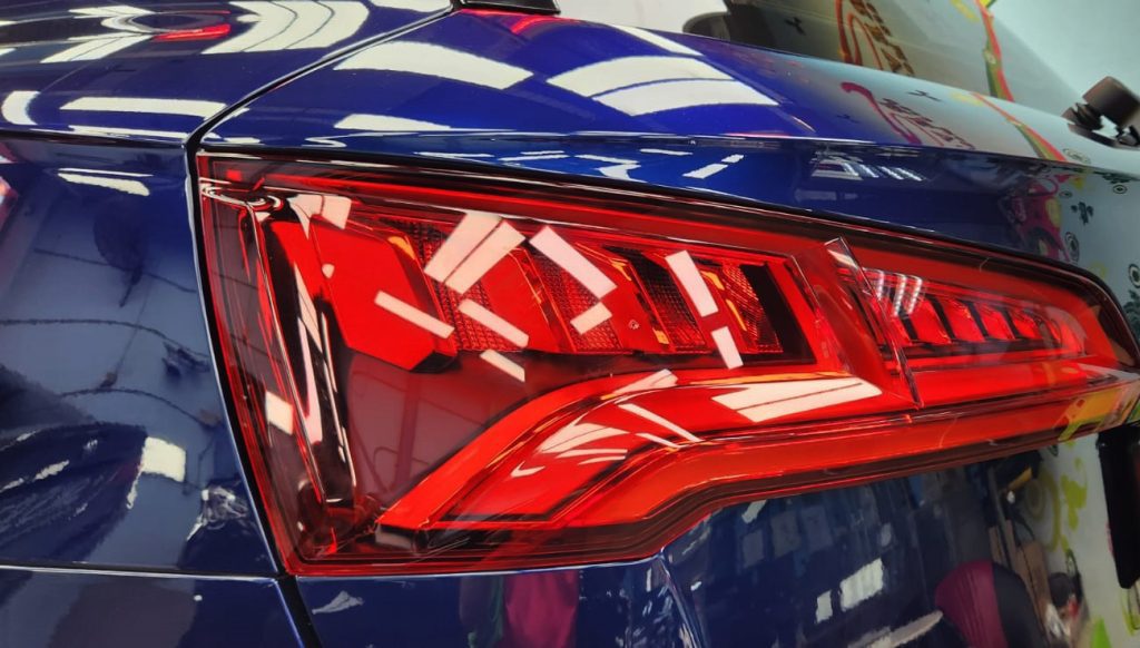 The coated bonnet of the Audi Q5 under workshop lighting.