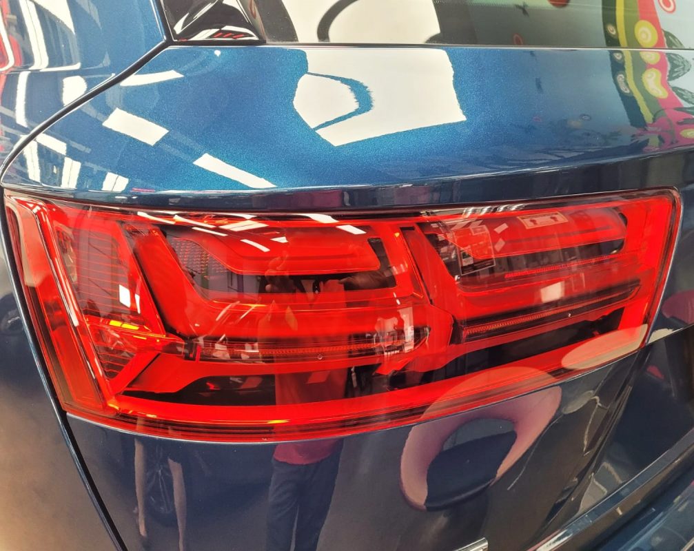The coated bonnet of the Audi Q7 under workshop lighting.