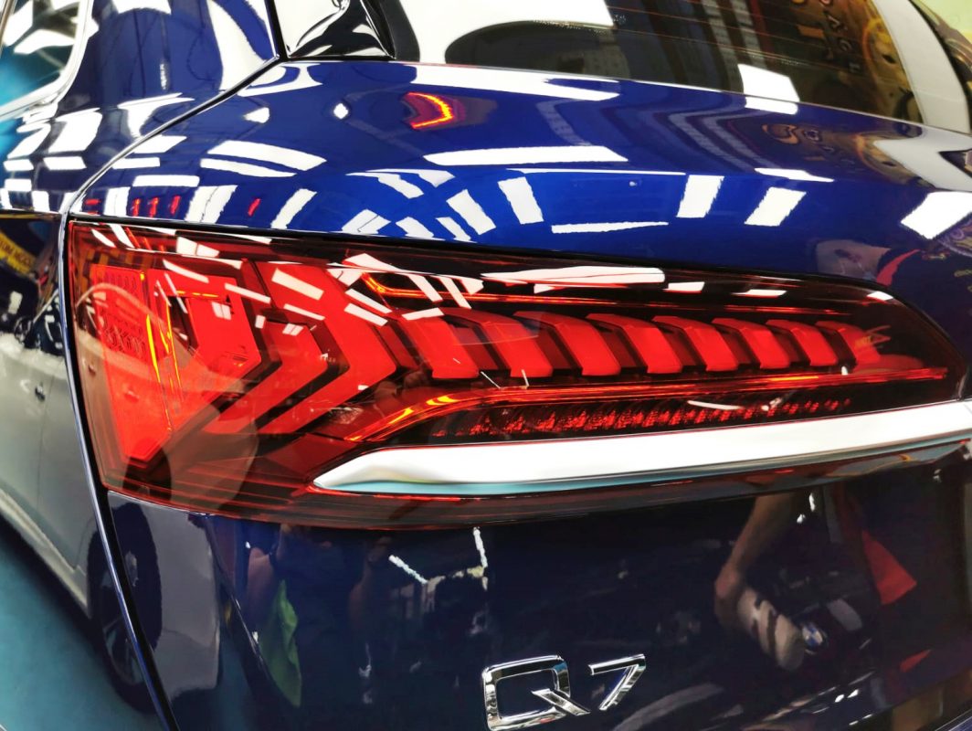 The coated bonnet of the Audi Q7 under workshop lighting.