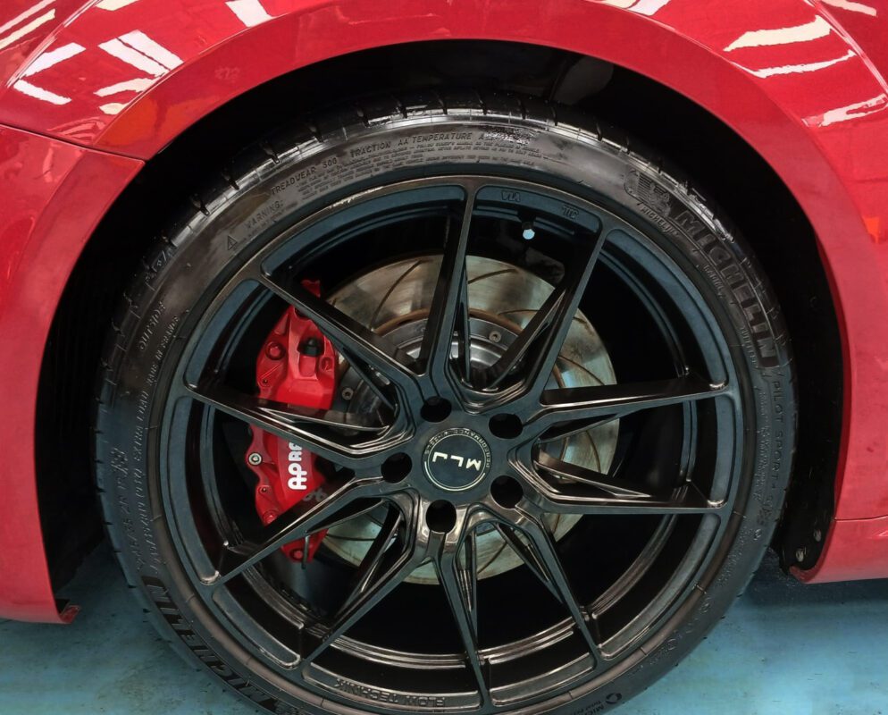 The coated bonnet of the Audi TT under workshop lighting.