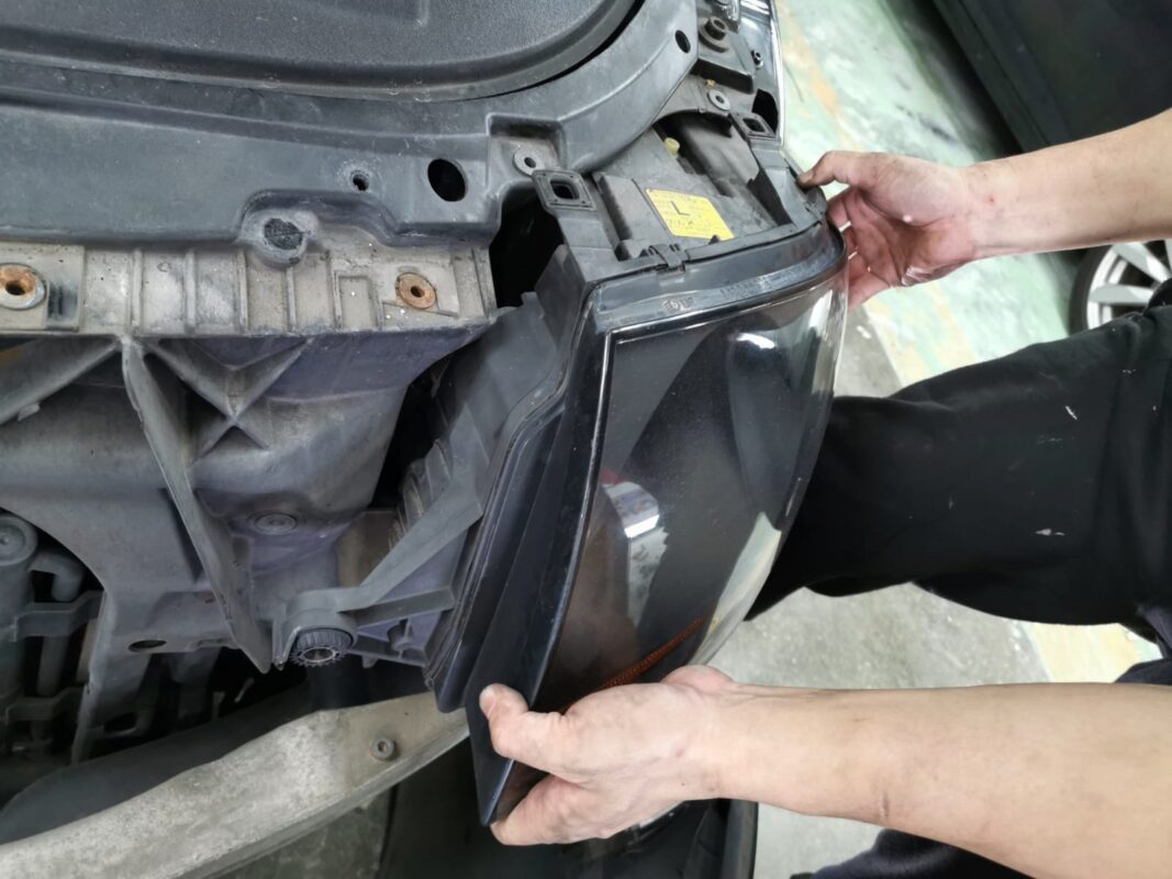 A headlight unit removed as the Audi TT is stripped down for the respray.