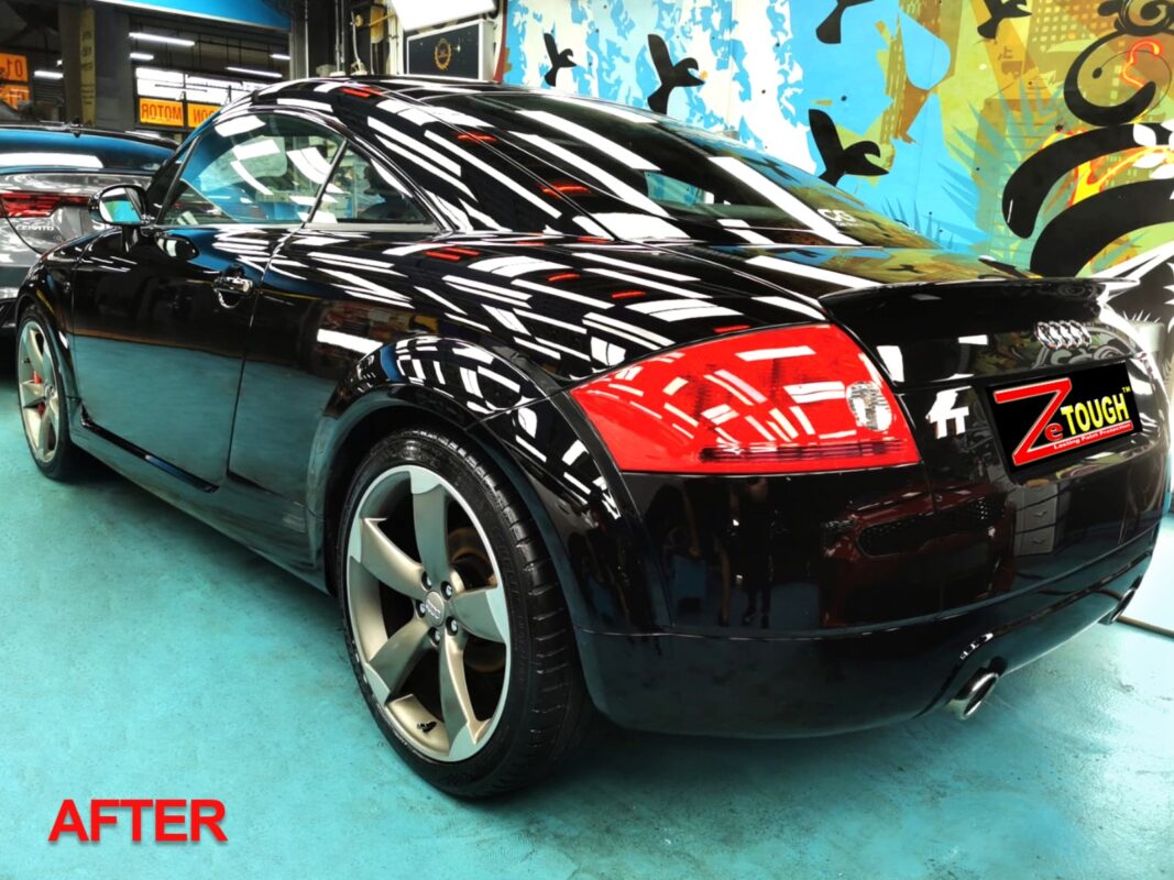 After: the same rear three-quarter, resprayed to a deep black gloss.