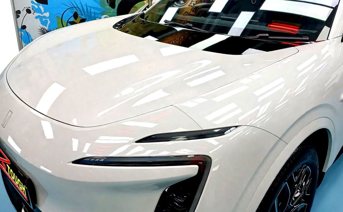 Bonnet and front lamp of the Avatr 07 with ceiling lights reflected in the paint.
