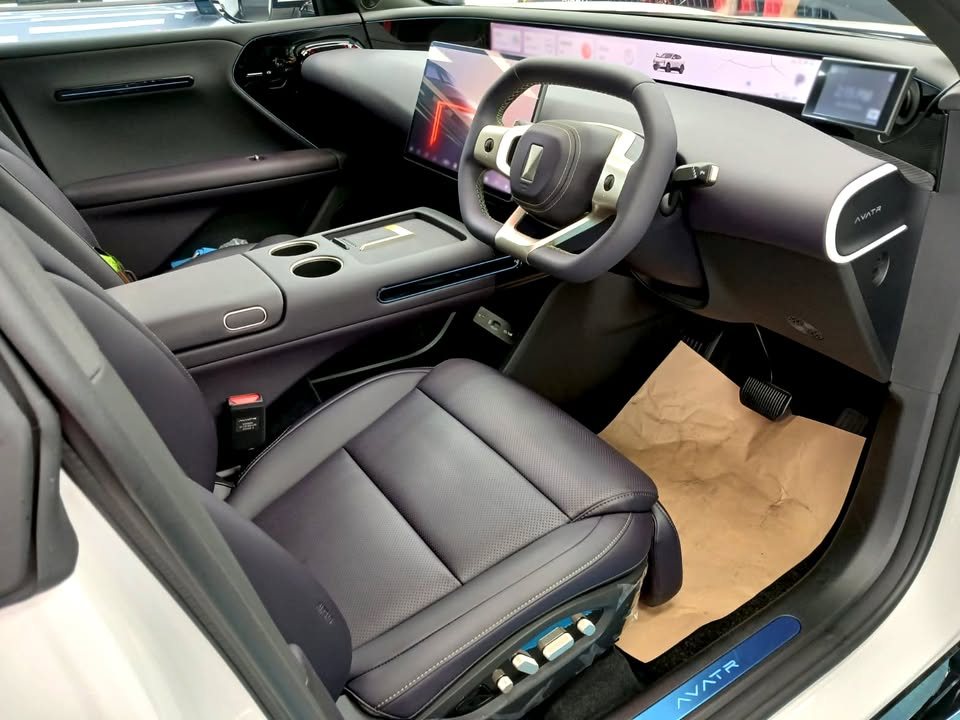 Front cabin of the Avatr 07 with dark seats, yoke-style wheel and wide dashboard screen.