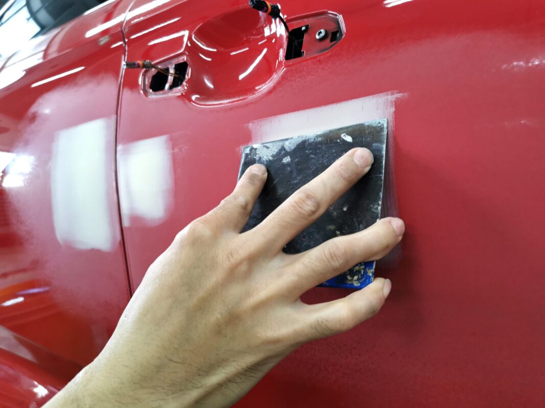 The BMW 1 Series panels under inspection at Revol Carz, scratches and imperfections visible before repair.