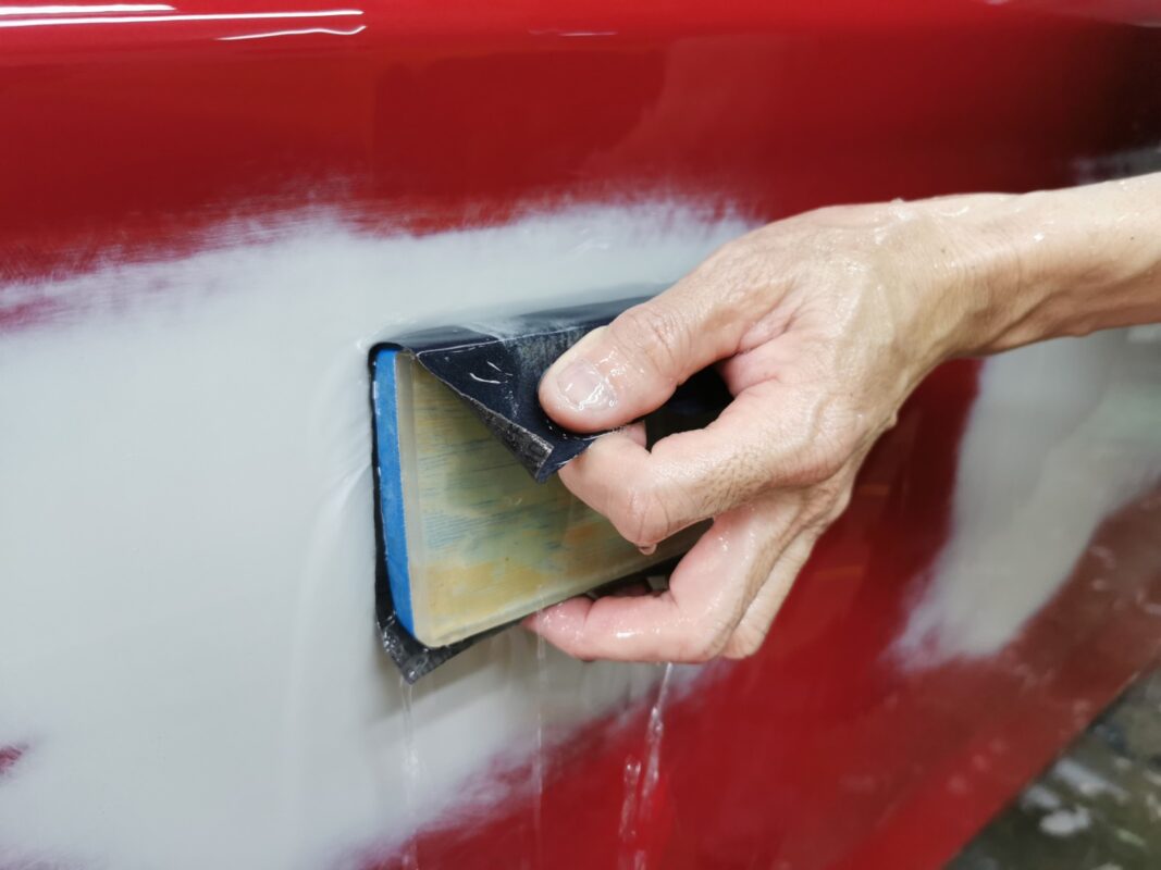 Wet-sanding continues on the BMW 1 Series, bringing the panels level and ready for primer.