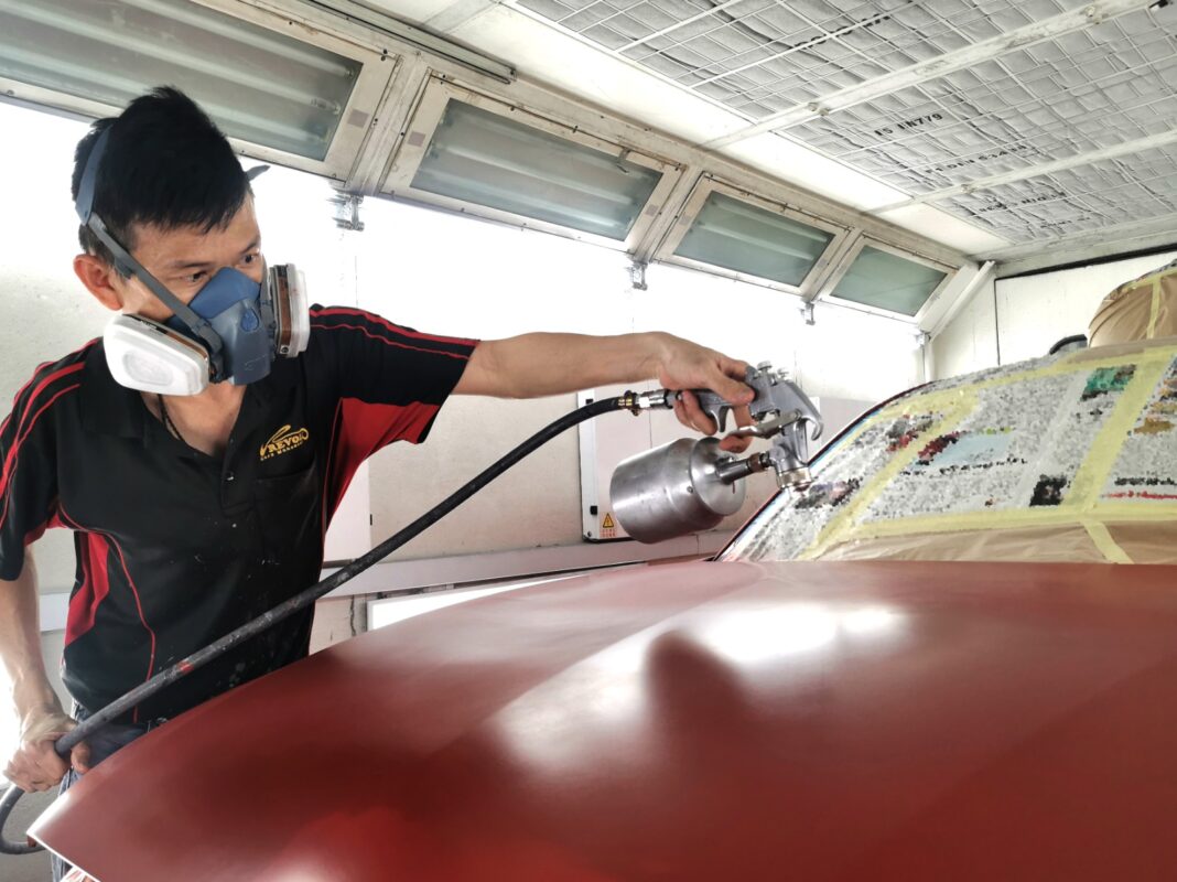 The BMW 1 Series inside the spray booth, the new coat being laid by a Revol Carz painter.