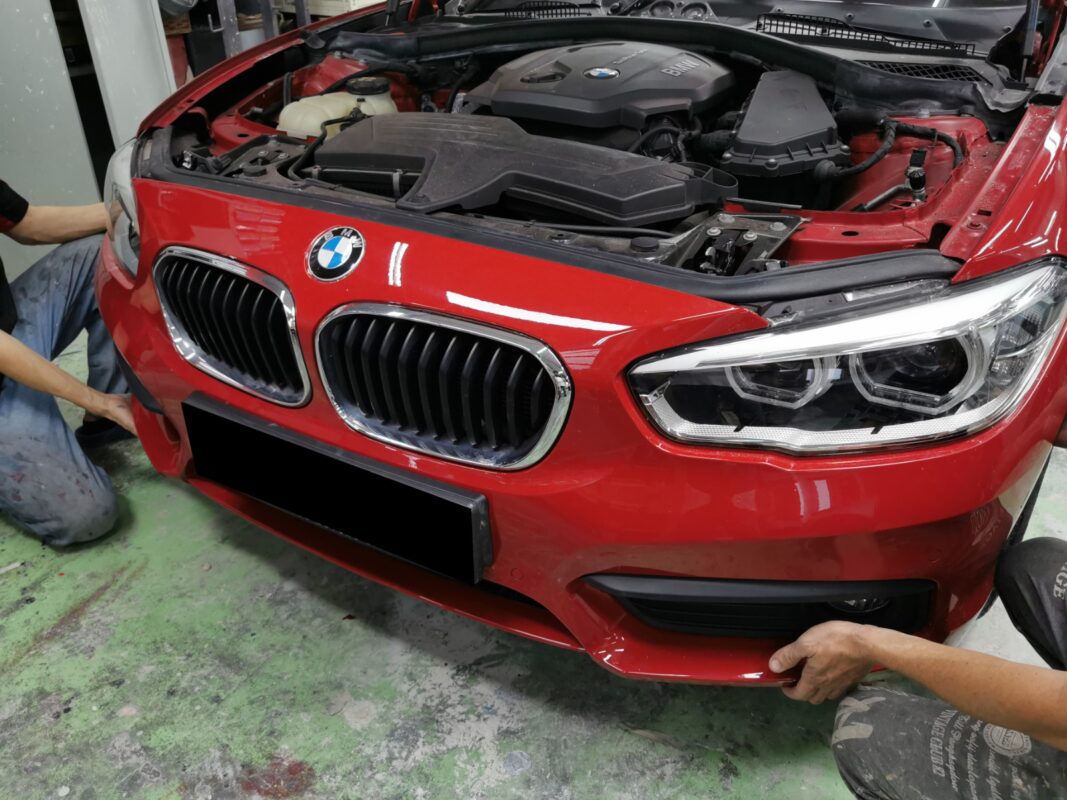 Machine-polishing the BMW 1 Series after painting, bringing up the gloss.