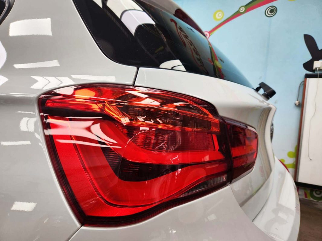 The coated bonnet of the BMW 116d under workshop lighting.