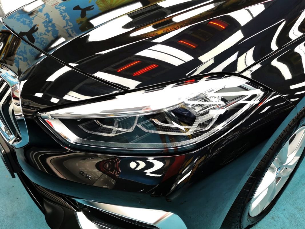 The 116i's coated paintwork holding clean reflections.