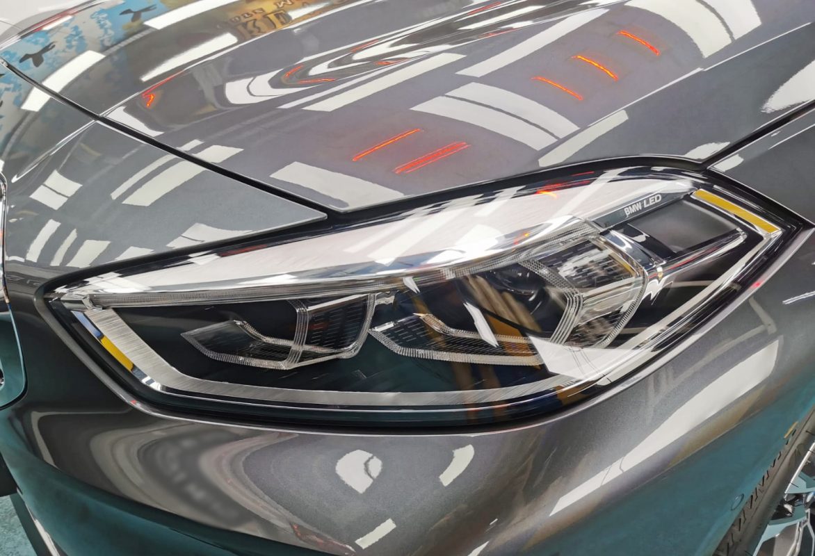 The 118i's coated paintwork showing clean reflections.