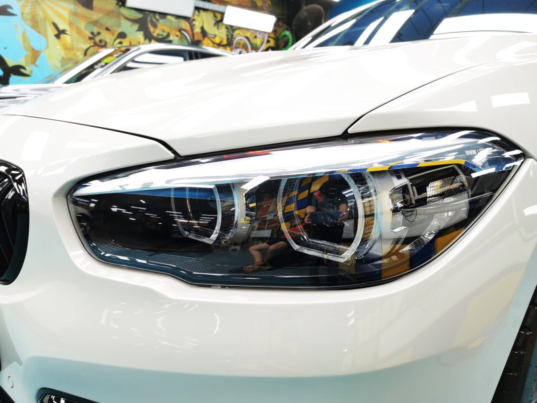 The 118i's coated paintwork showing clean reflections.