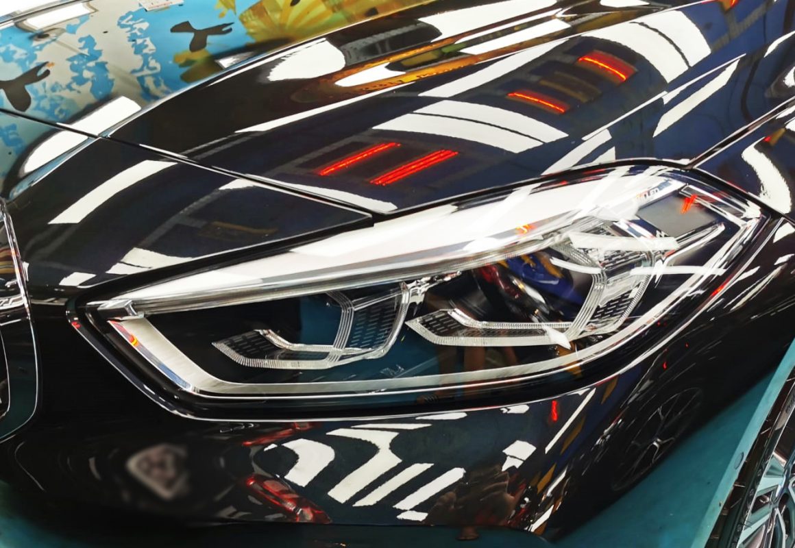 The 118i's coated paintwork showing clean reflections.
